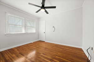 Spare room featuring crown molding, wood finished floors, and ceiling fan
