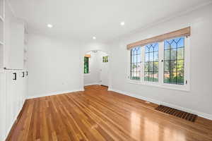 Unfurnished living room with arched walkways, healthy amount of natural light, light wood-type flooring, and recessed lighting