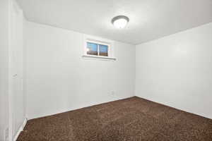 Carpeted empty room featuring a textured ceiling