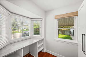 Unfurnished room featuring dark wood-style floors and baseboards