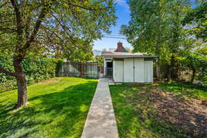 Fenced backyard with an outdoor structure and a gate