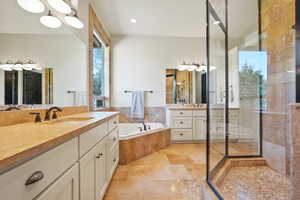 Bathroom with a bath, two vanities, and a stall shower