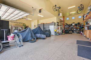 Garage with freestanding refrigerator, a workshop area, and a heating unit