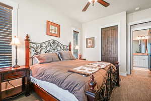 Bedroom featuring a closet, ceiling fan, connected bathroom, and carpet floors