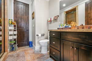 Full bathroom with vanity, ornamental molding, and light stone finish floors