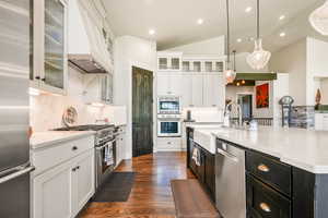 Kitchen with white cabinetry, dark cabinetry, dark wood-style flooring, lofted ceiling, and recessed lighting