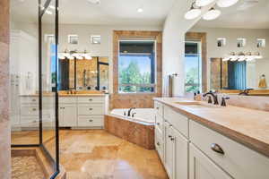 Full bath with two vanities, a garden tub, a stall shower, and recessed lighting