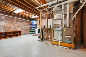 Unfinished basement featuring water heater and heating unit