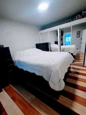 Bedroom with wood finished floors and multiple closets