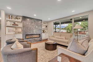 Living area with light wood-style flooring, a fireplace, and recessed lighting