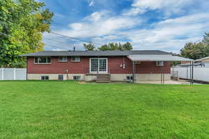 Rear view of property featuring brick siding, entry steps, and a patio area