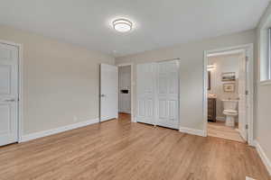 Unfurnished bedroom with light wood-type flooring and ensuite bathroom