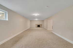 Below grade area with a fireplace and carpet flooring