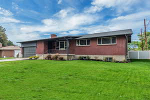 Ranch-style house with brick siding, driveway, a chimney, and a garage