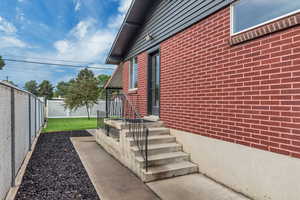 View of side of home featuring brick siding and a fenced backyard