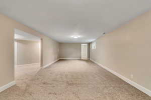 Empty room with light carpet and baseboards