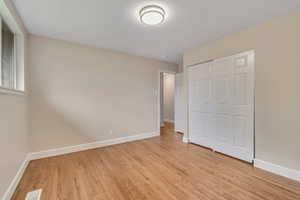 Unfurnished bedroom with light wood finished floors and a closet