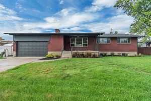 Single story home featuring covered porch, brick siding, concrete driveway, a chimney, and an attached garage