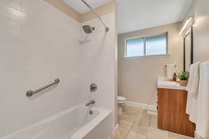 Full bathroom with vanity, washtub / shower combination, and light tile patterned floors