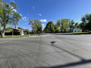 View of asphalt street featuring sidewalks and curbs