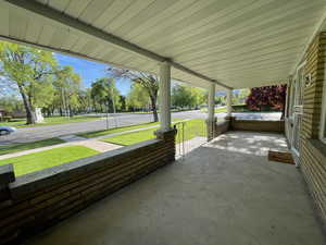 Covered porch featuring a yard