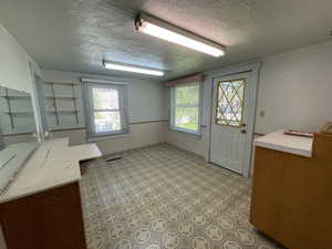 Interior space with a textured ceiling and a desk
