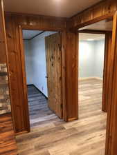 Hallway featuring light wood-type flooring and baseboards
