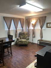 Sitting room with dark wood-style floors and a textured ceiling