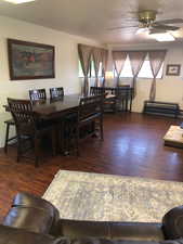 Dining space with dark wood-type flooring and ceiling fan