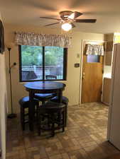 Dining room with brick patterned flooring and a ceiling fan