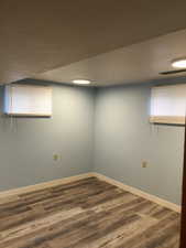 Empty room featuring dark wood-style flooring and baseboards