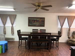 Dining space featuring dark wood finished floors and a baseboard radiator