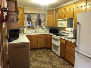 Kitchen with white appliances, light countertops, and brick patterned flooring