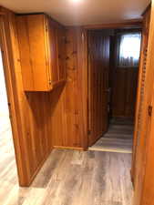 Hallway featuring wood finished floors and wood walls