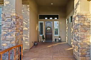 Property entrance featuring stucco siding and a patio