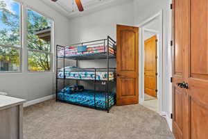 Bedroom with light colored carpet and a ceiling fan