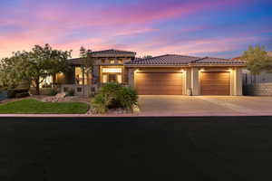 Mediterranean / spanish home with a garage, stucco siding, driveway, and a tile roof