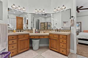 Full bathroom with backsplash, ensuite bathroom, ceiling fan, double vanity, and a stall shower