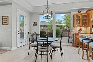 Dining room with healthy amount of natural light, a chandelier, and light wood finished floors