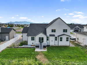 Back of property featuring a residential view, stucco siding, a patio, roof with shingles, and a mountain view