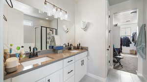 Full Master bath with double vanity and a shower stall