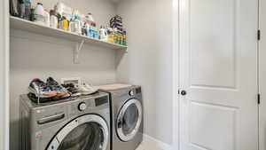 Laundry room with independent washer and dryer and baseboards