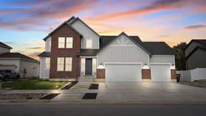 View of front of house featuring board and batten siding, concrete driveway, and a garage