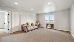 Sitting room featuring light colored carpet, recessed lighting, and a textured ceiling