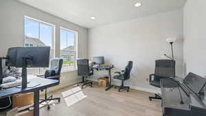 Office space featuring light wood-style floors and recessed lighting