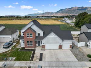 View of front of property featuring board and batten siding, driveway, an attached garage, and a mountain view