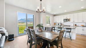Dining room featuring light wood-style flooring, recessed lighting, a chandelier, and a mountain view