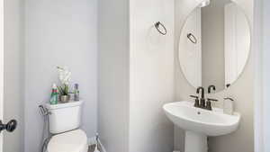 Half bathroom featuring toilet and baseboards