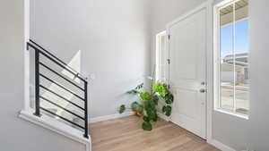 Entryway featuring light wood finished floors and stairs