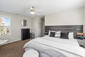 Bedroom featuring dark colored carpet and a ceiling fan